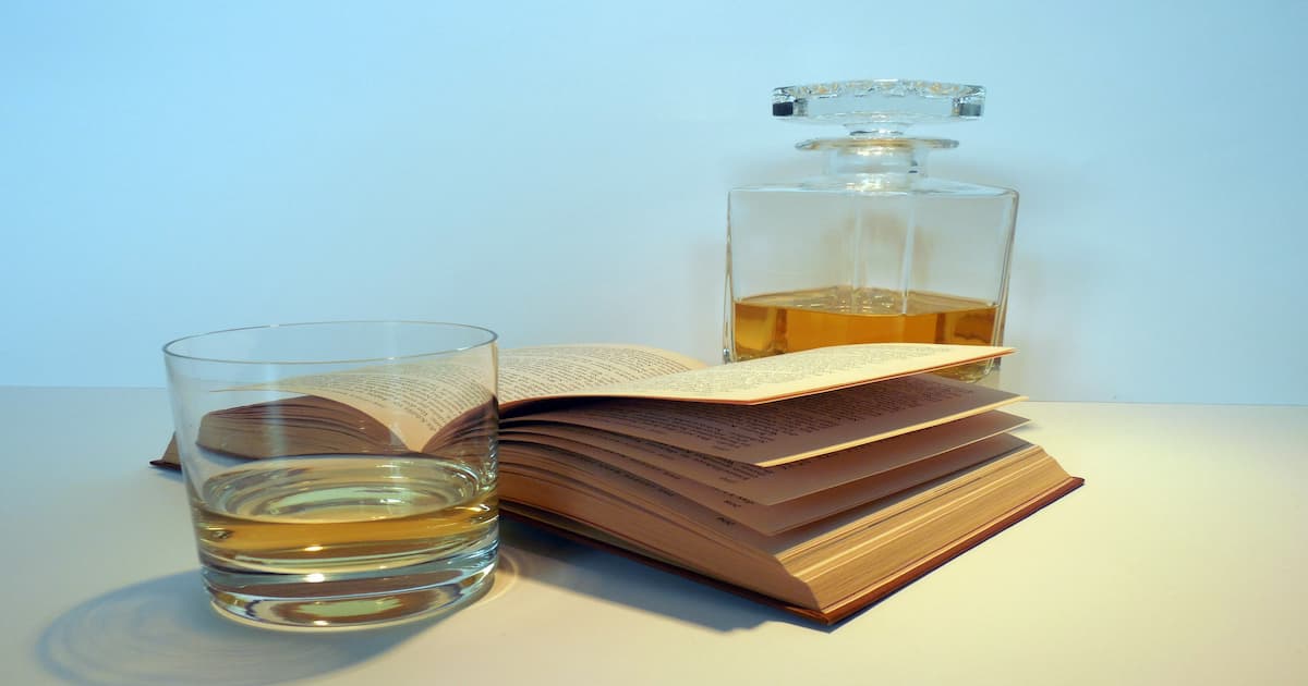 Whisky decanter with glass and book. Implying liquor tax law.